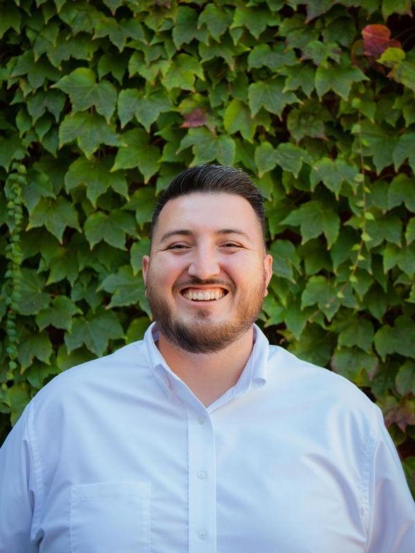 Jesse Magaña standing in front of ivy outside of DeRosa University Center